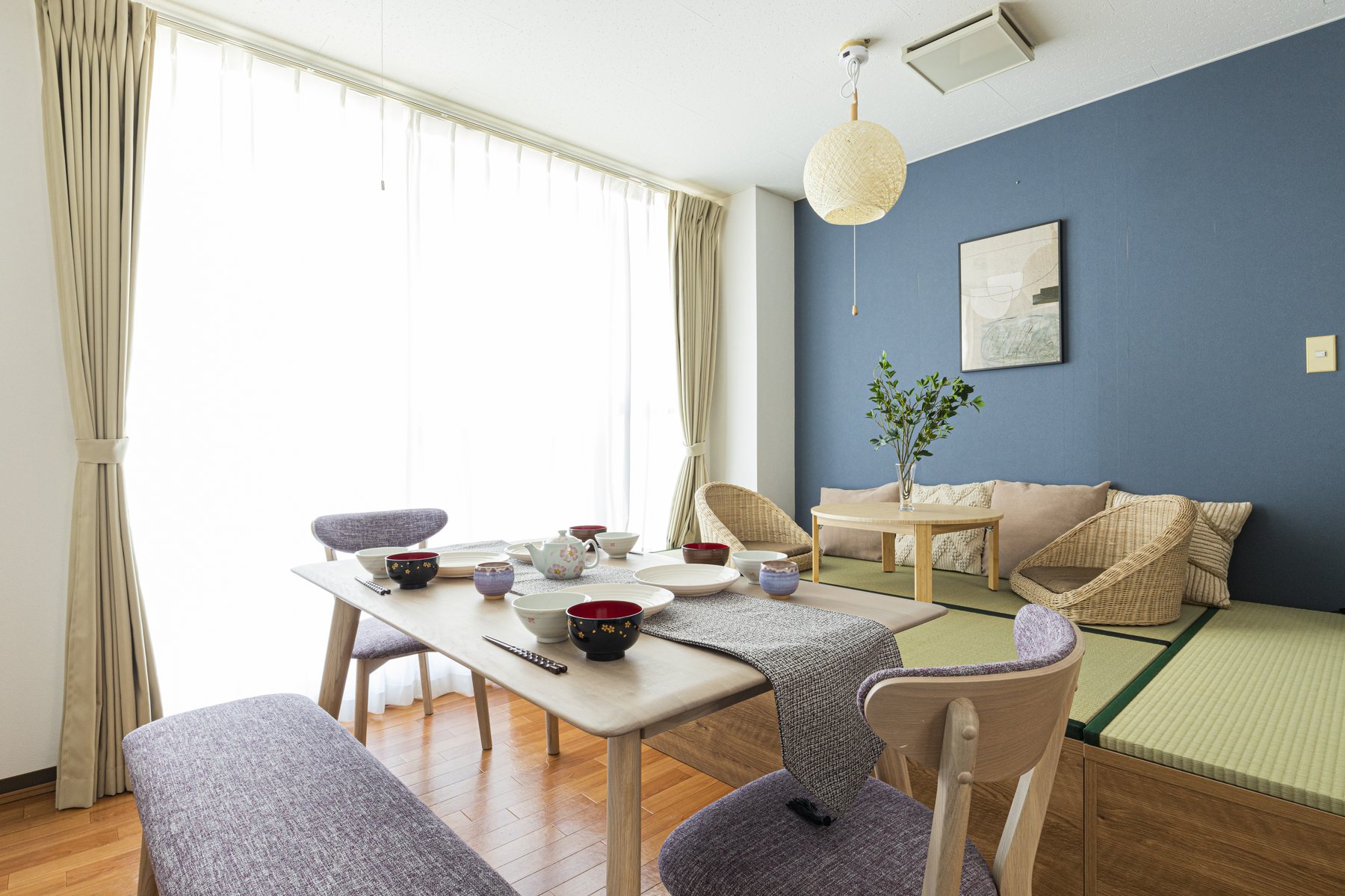 ダイニングテーブルと使い込まれたキッチン道具が並ぶ、TiareHomeのリビングの様子